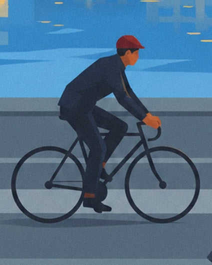 Der Radfahrer mit roter Mütze auf seinem schwarzen Fahrrad neben dem Wasserspiegel