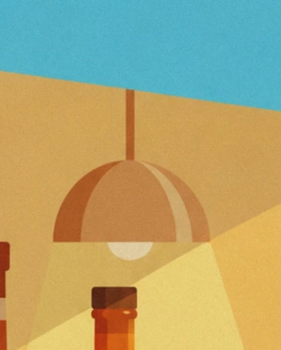 The orange pendant light and its pale bulb above the neck of an amber bottle