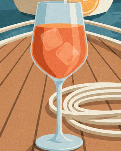 A glass of spritz with orange ice cubes and a coiled rope on the wooden deck