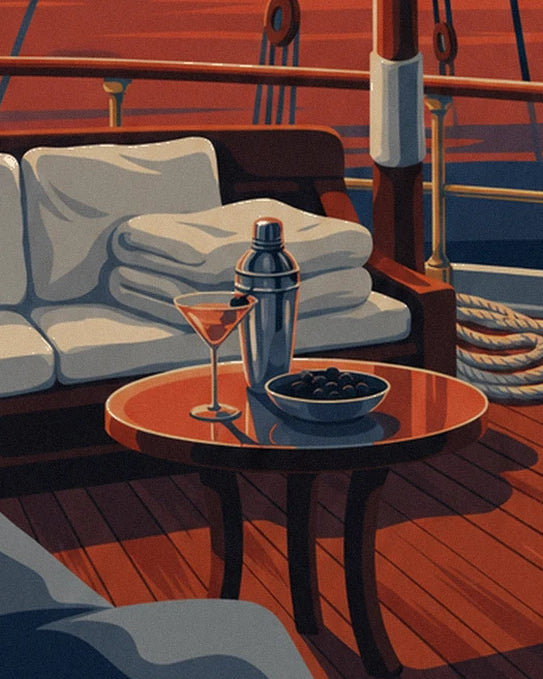 The silver cocktail shaker, martini glass and bowl of olives on the sailing boat's table