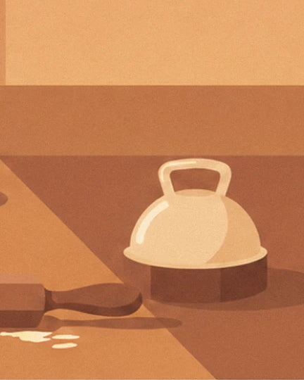 La cloche crème à poignée sur son socle brun, près du rouleau à pâtisserie