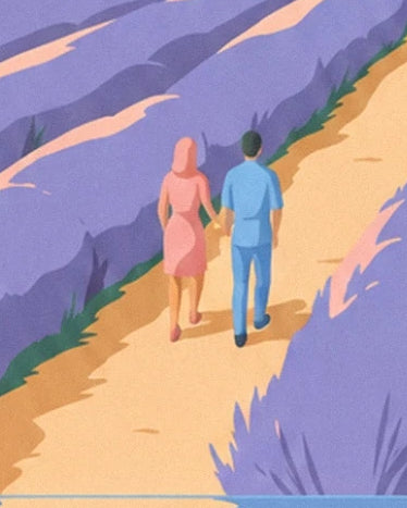 A couple in pink and blue holding hands on the path between the lavender