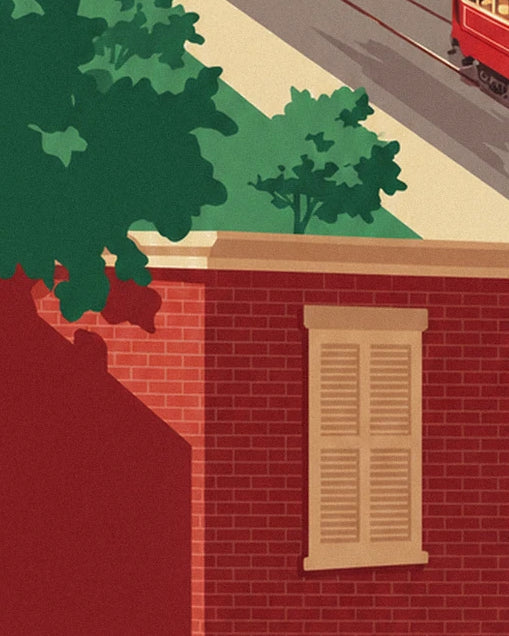 Le mur de brique rouge et sa fenêtre à volets beiges, sous le feuillage vert