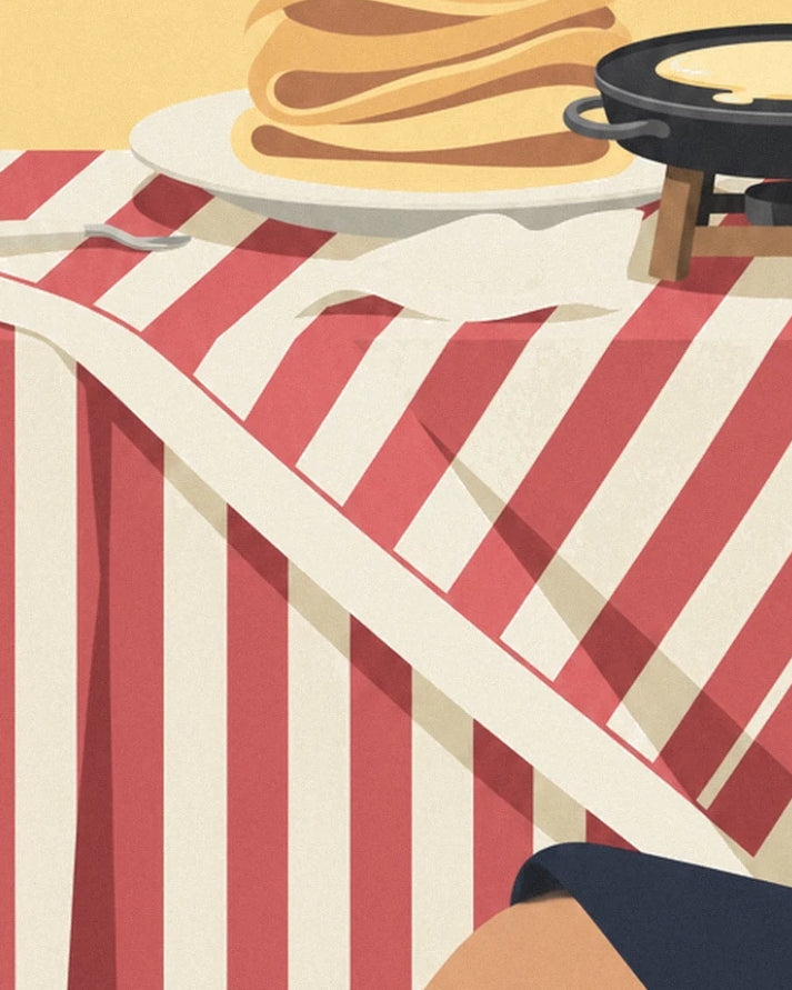 La nappe à rayures rouges et crème sous l’assiette de crêpes et la crêpière