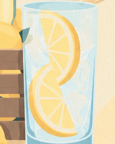 The tall blue-tinted glass filled with ice cubes and 2 lemon slices