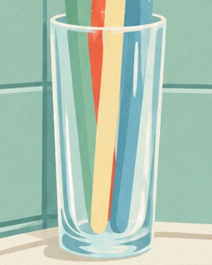 Das durchsichtige Glas mit bunten Zahnbürstengriffen neben dem Waschbecken