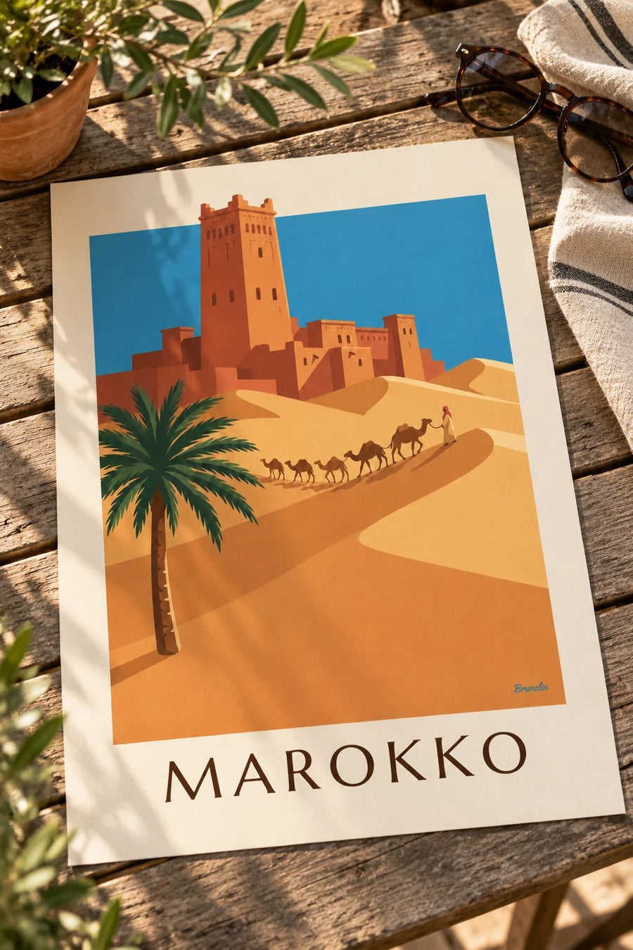 Poster Kasbah und Kamelkarawane in der marokkanischen Wüste: auf einem Tisch