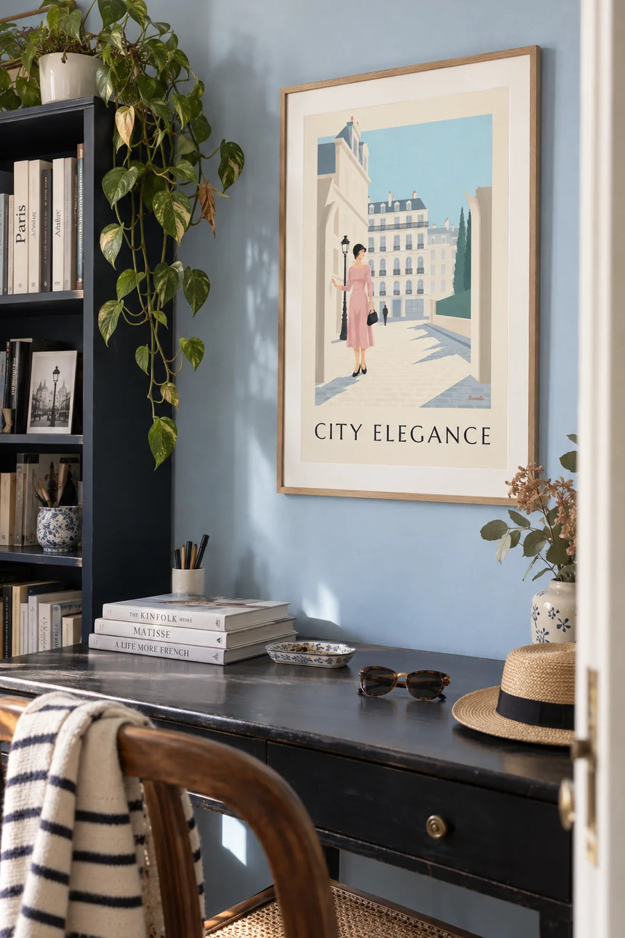 Affiche femme raffinée devant une façade de ville en noir et pastel : encadrée au mur