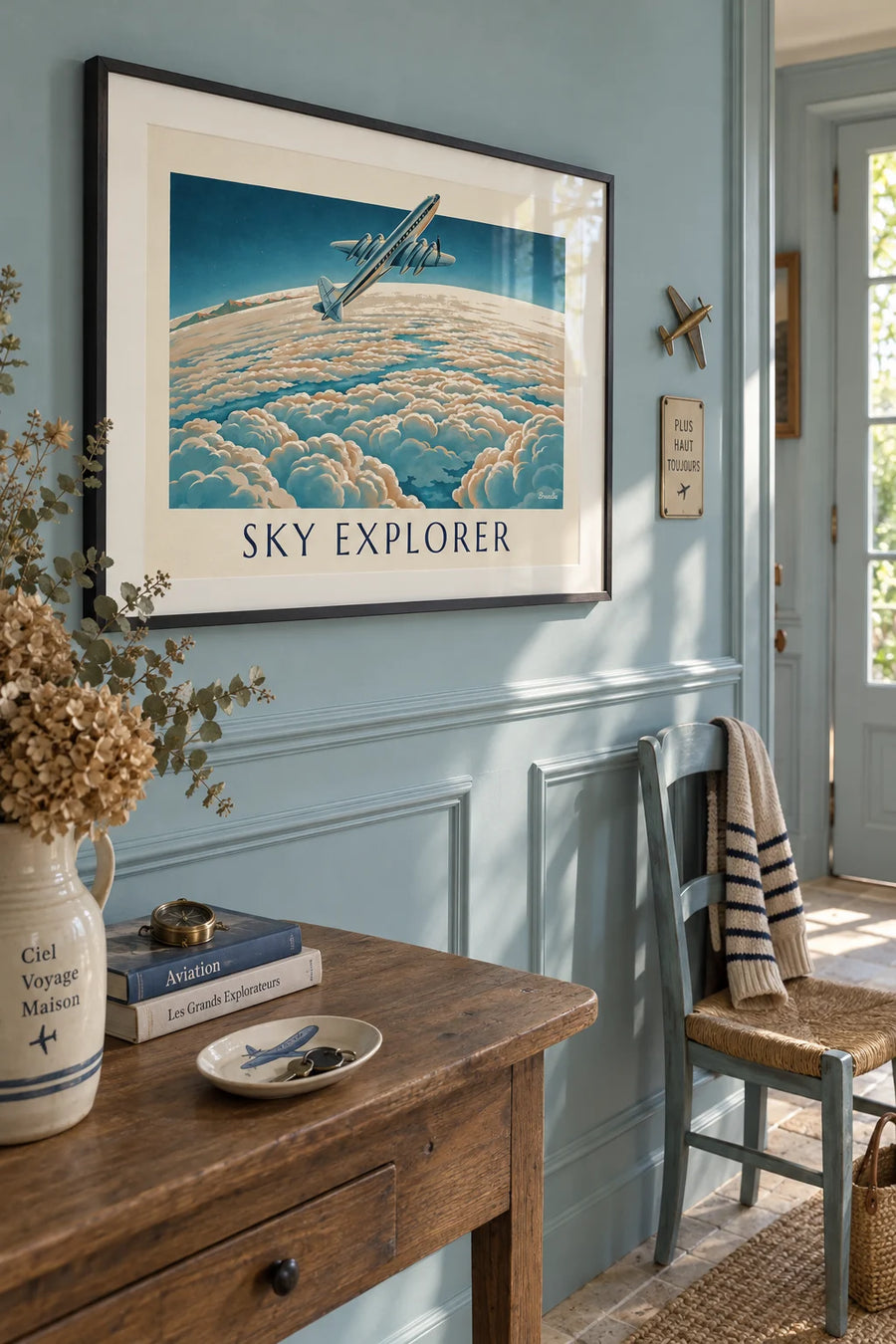 Poster of an airliner above a sea of clouds: framed on the wall