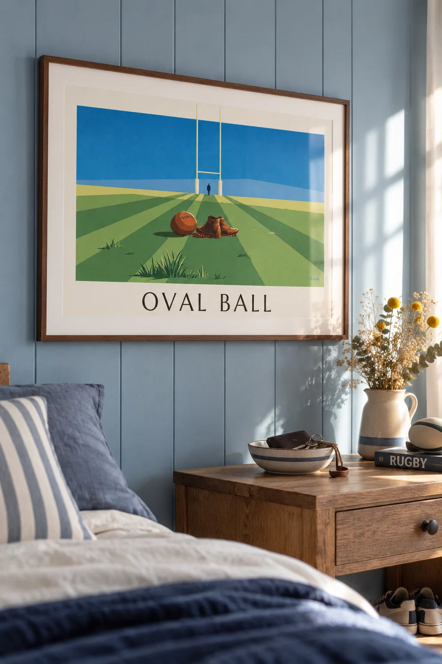 Poster of a leather rugby ball and cleats on a rugby field: framed on the wall