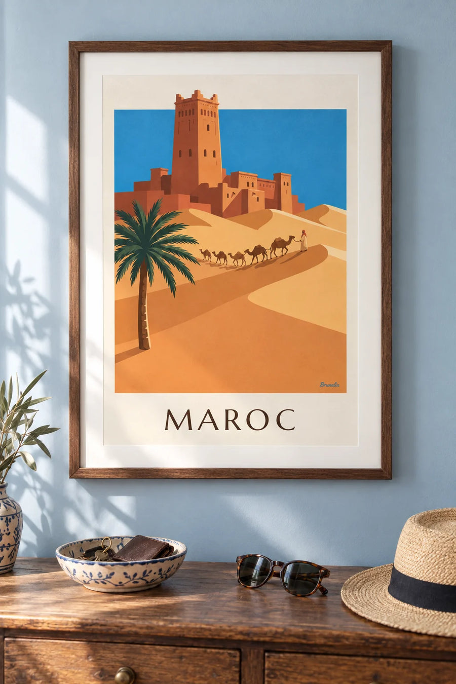 Poster of a kasbah and camel caravan in the Moroccan desert: framed on the wall